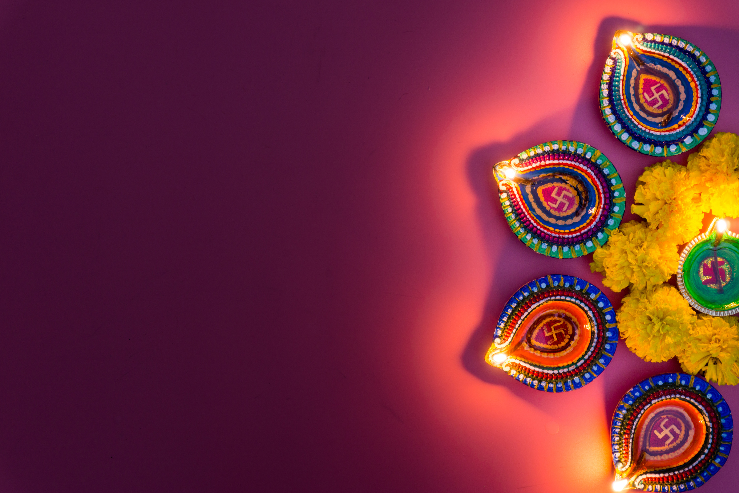 Indian festival Diwali, Diya oil lamps lit on colorful rangoli. Hindu traditional. Happy Deepavali. Copy space for text.